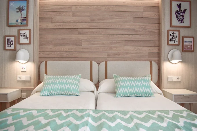 Beach-themed twin bedroom with wood headboard at Ambassador Playa 2