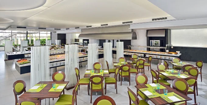 Main buffet restaurant at Meliá Benidorm with green chairs and live cooking stations