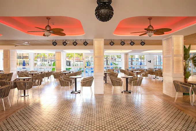Bright buffet dining room at Ambassador Playa 2 with rattan chairs