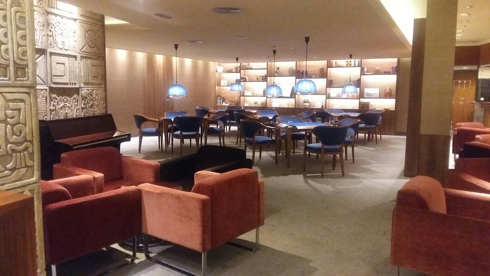 Lobby lounge with piano and signature Mayan stone wall at Hotel Don Pancho