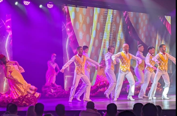 Male dancers on stage in yellow and white costumes
