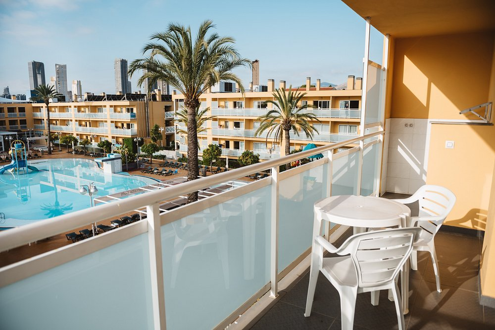 Pool-view apartment balcony at Terralta Apartments Benidorm with table and chairs