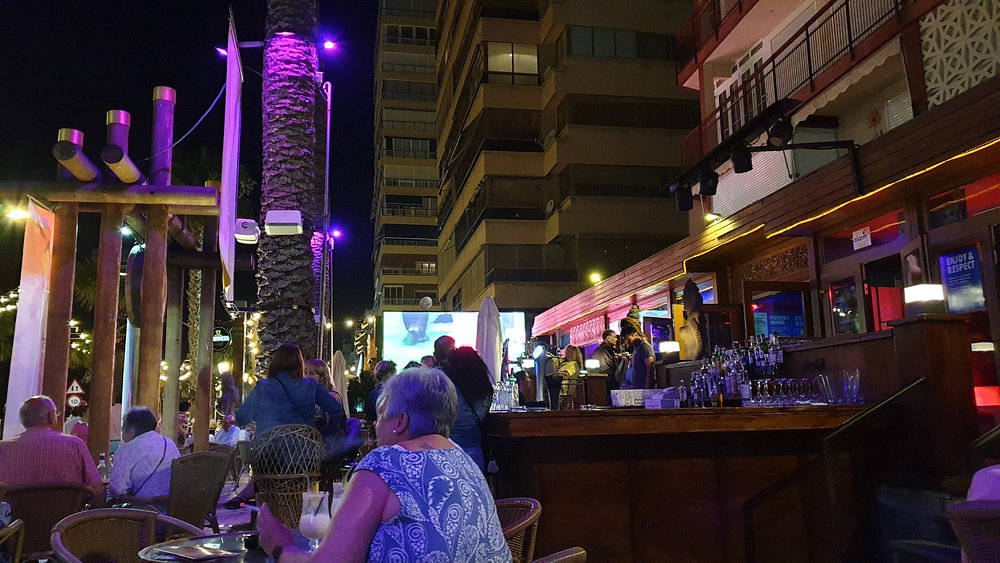 KU Benidorm beachfront bar at night with purple lights