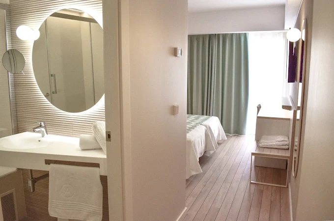 Modern round-mirror bathroom and bedroom view at Ambassador Playa 2