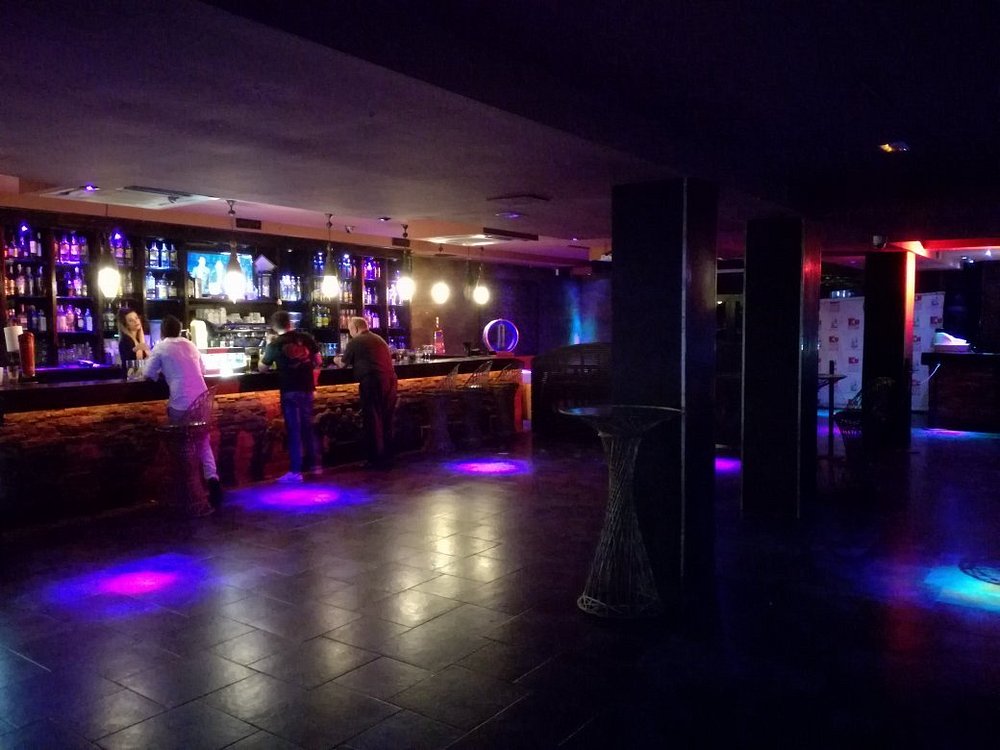 Interior of the KU Benidorm club with purple neon lights and long bar