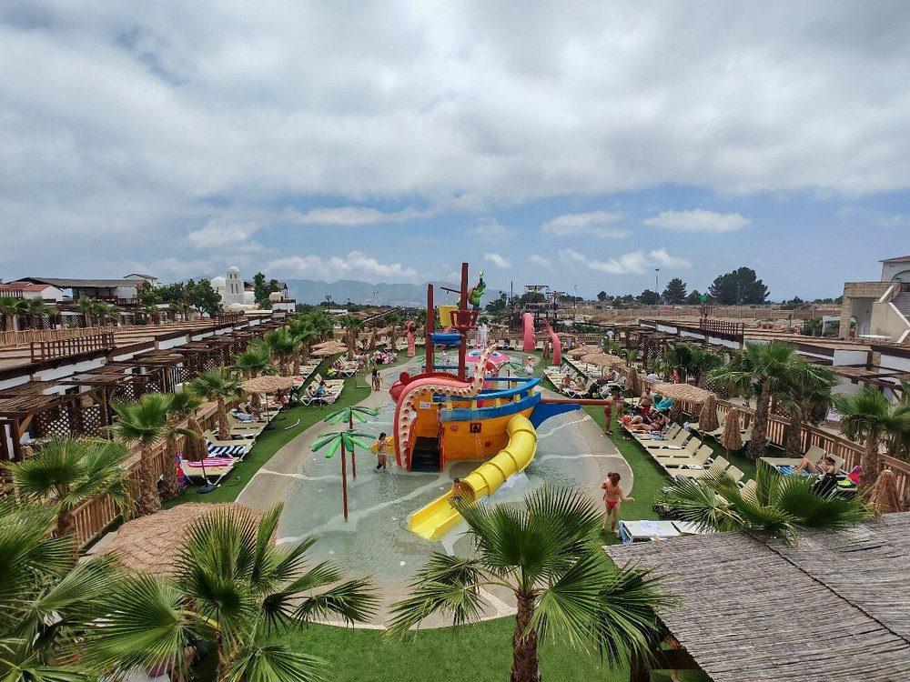 Children's splash park at Magic Pirates Island Resort with palm trees and slides