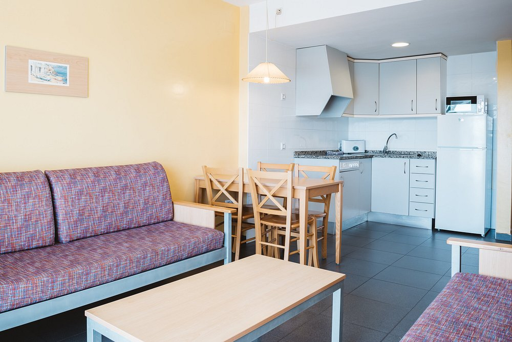 Open-plan kitchen, dining table and sofa inside a Terralta apartment in Benidorm