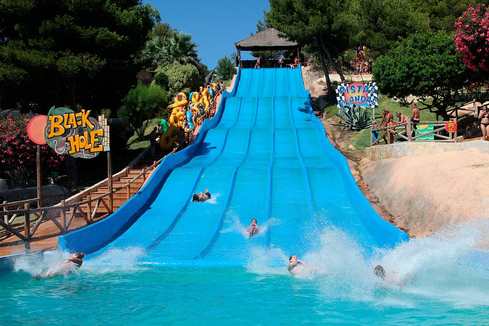 Black Hole slide at Aqualandia Benidorm Black Hole slide at Aqualandia Benidorm with riders descending the wide blue multi-lane aquapark slope
